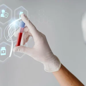 Gloved hand holding a red-blood sample in a test tube with holographic medical icons around it, in a lab setting.